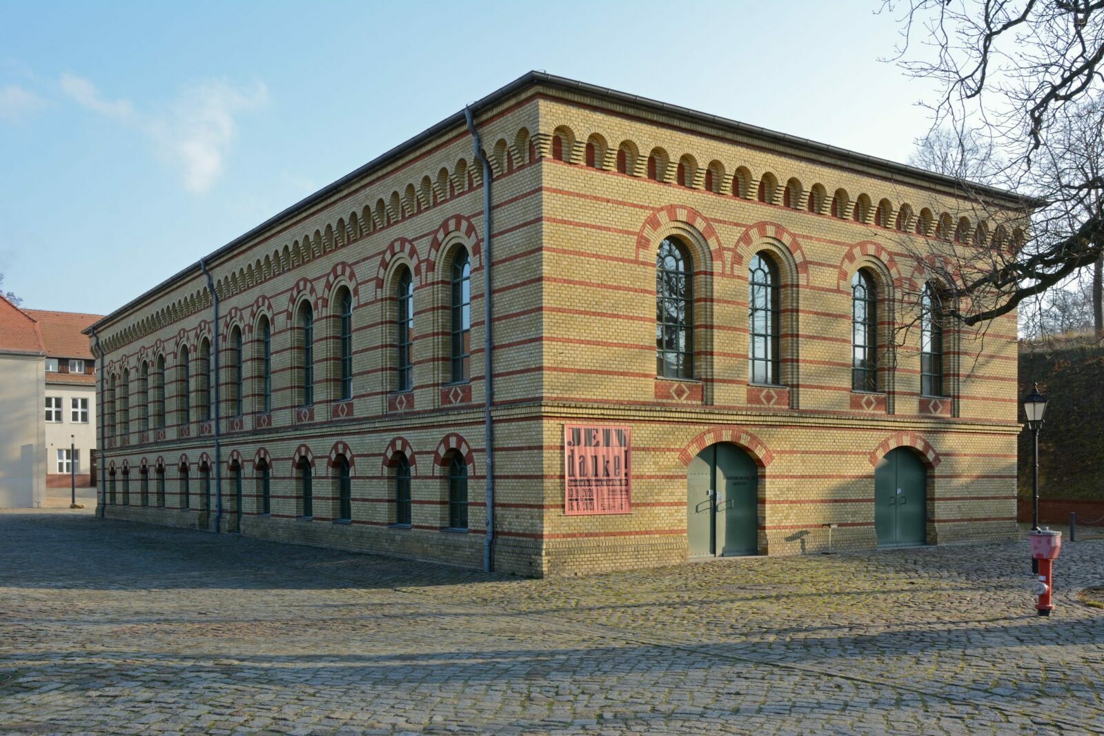 Zweistöckiges Ziegelsteingebäude mit Rundbogenfenstern